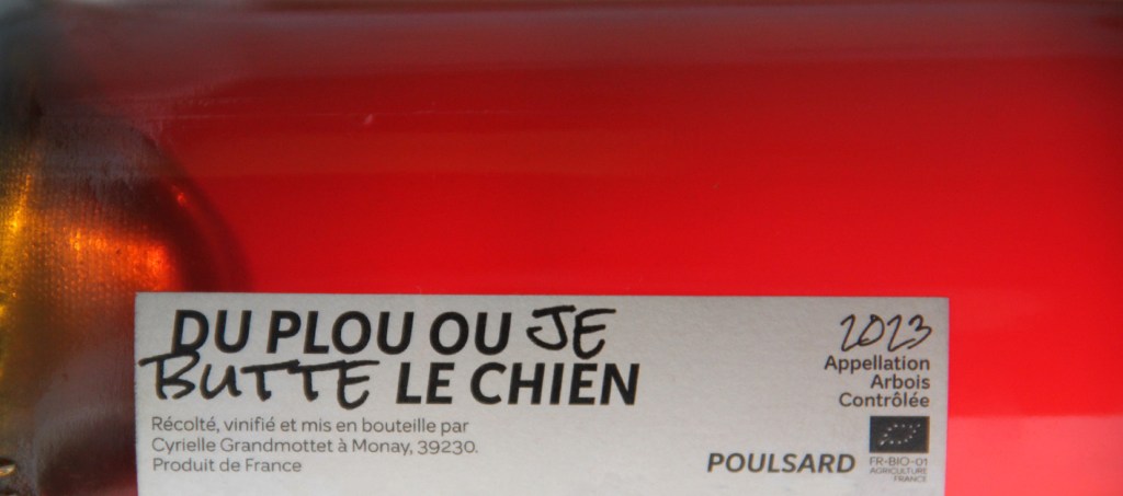 Gros plan de l'étiquette de vin qui montre le titre de la cuvée et la couleur du vin.